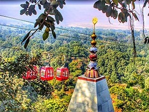 The Ashtabhuja temple, a Hindu temple located in Vindhyachal, India. The temple has a beautiful architecture with intricate carvings and decorations. There are several towers and spires visible, and there are people walking around the temple complex.