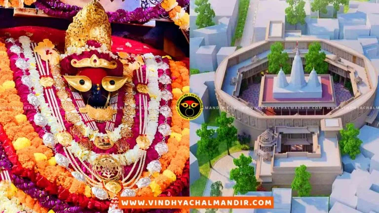 A view of the Vindhyachal temple complex, a Hindu temple located in Vindhyachal, India. The image shows the temple's entrance with intricate carvings and decorations, as well as several towers and spires. There are people walking around the temple complex, and there is a beautiful blue sky in the background.